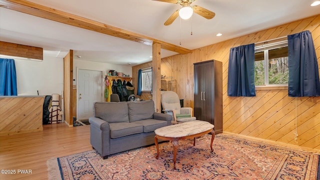 living area featuring recessed lighting, a ceiling fan, wood walls, and wood finished floors