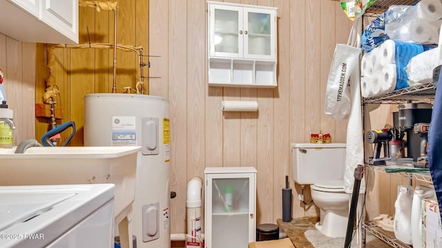 interior space with laundry area, wood walls, and water heater
