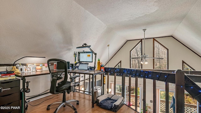 office area featuring a textured ceiling, vaulted ceiling, and wood finished floors