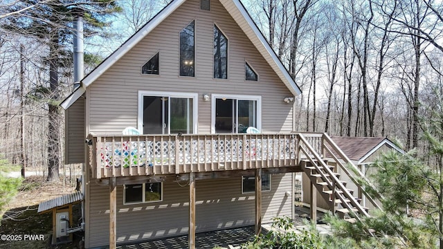back of property featuring a wooden deck and stairs