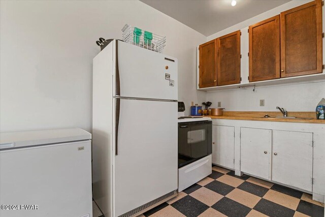 1075 Owego Tpke, Honesdale, PA 18431 - kitchen featuring white appliances, light floors, light countertops, and brown cabinetry