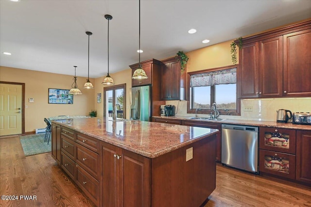 1075 Owego Tpke, Honesdale, PA 18431 - kitchen with appliances with stainless steel finishes, decorative backsplash, dark wood finished floors, a center island, and light stone countertops
