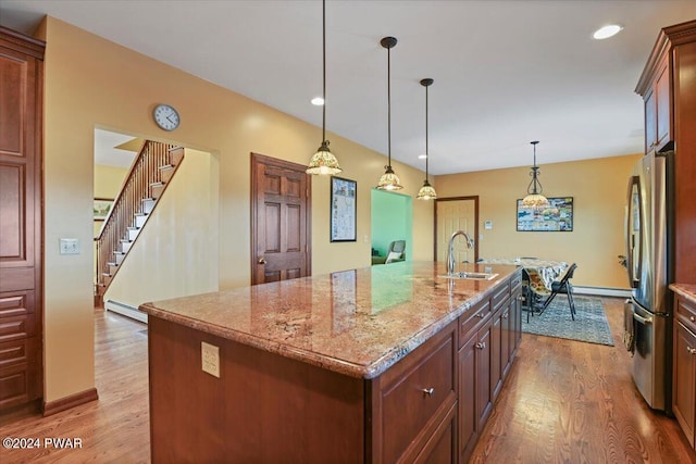 1075 Owego Tpke, Honesdale, PA 18431 - kitchen featuring freestanding refrigerator, wood finished floors, a center island with sink, light stone countertops, and recessed lighting