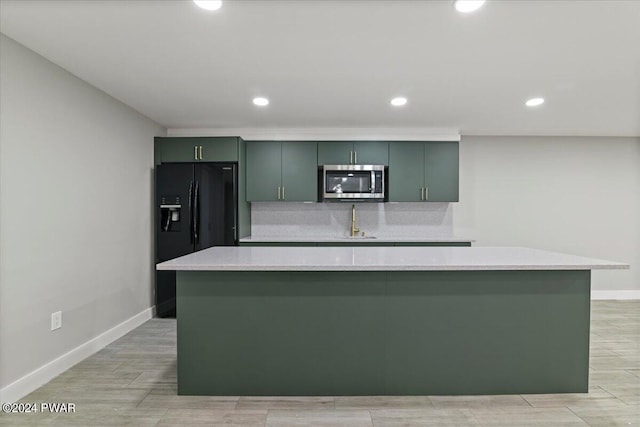 1075 Owego Tpke, Honesdale, PA 18431 - kitchen with stainless steel microwave, black fridge, light countertops, a spacious island, and recessed lighting