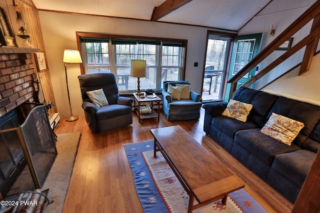 150 N Lake Dr, Dingmans Ferry, PA 18328 - living room featuring wood finished floors, a baseboard radiator, a brick fireplace, stairs, and wooden walls