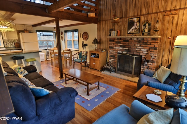 150 N Lake Dr, Dingmans Ferry, PA 18328 - living room featuring wooden walls, wood finished floors, a brick fireplace, and beam ceiling