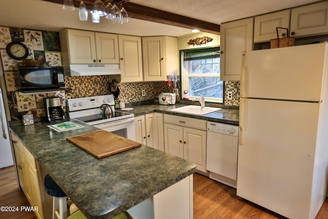 kitchen with beam ceiling, sink, light hardwood / wood-style floors, a textured ceiling, and white appliances