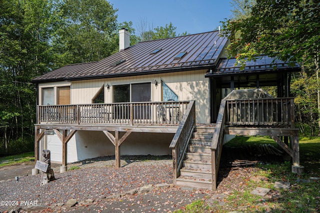 back of house with a deck and a garage