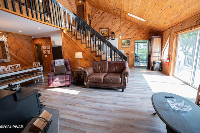 living room with plenty of natural light, light hardwood / wood-style floors, wooden ceiling, and lofted ceiling with skylight