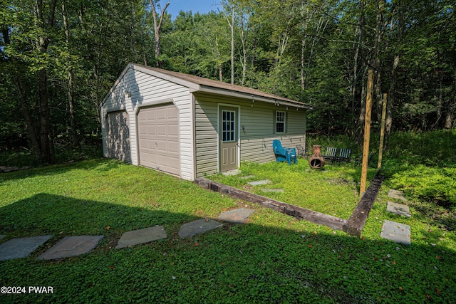 view of outdoor structure with a lawn and a garage