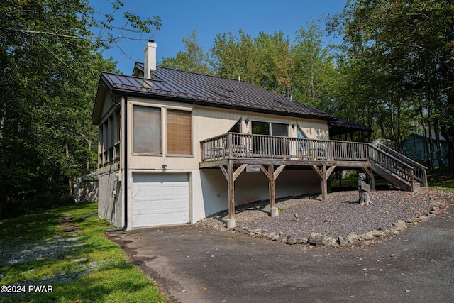 view of front of home with a sunroom, a garage, and a deck