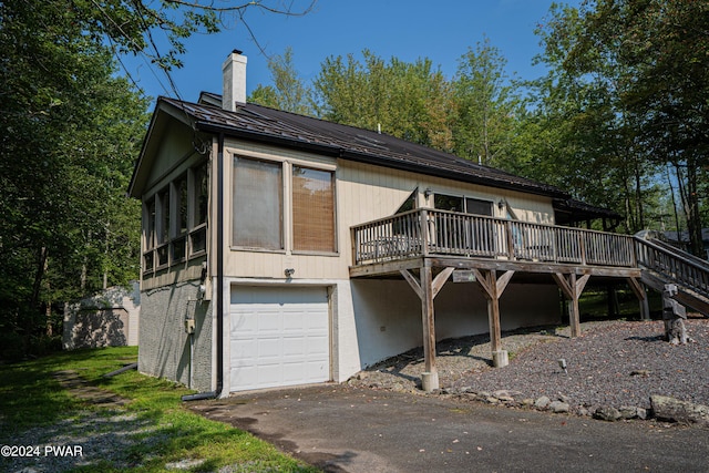 view of front of home with a sunroom, a deck, and a garage