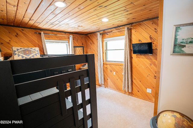 bedroom featuring wooden walls, carpet, and wood ceiling