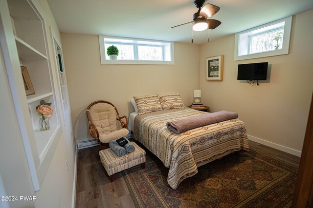 bedroom featuring baseboard heating, ceiling fan, and dark wood-type flooring