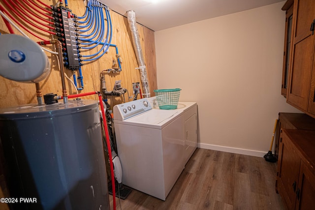 laundry room featuring washing machine and clothes dryer, dark wood-type flooring, and water heater