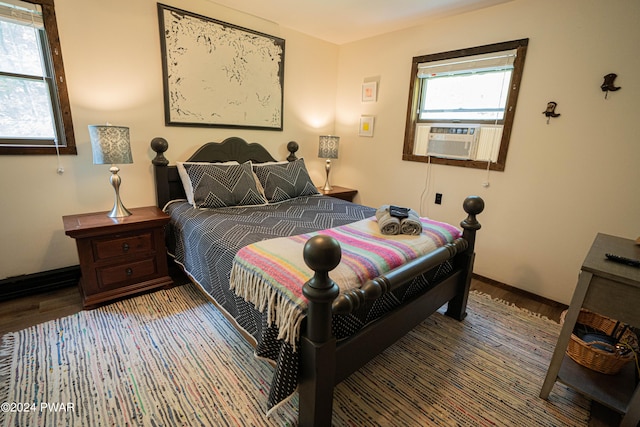 bedroom featuring multiple windows, hardwood / wood-style floors, and cooling unit