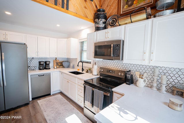 kitchen featuring white cabinets, sink, dark hardwood / wood-style floors, decorative backsplash, and stainless steel appliances