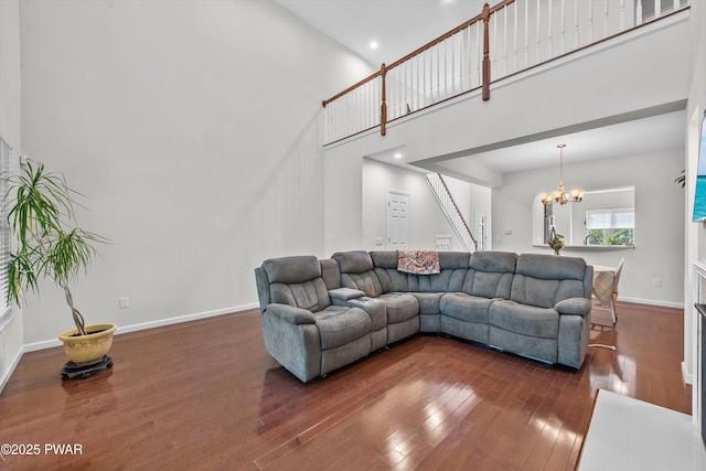 309 Braeburn Path, Matamoras, PA 18336 - living room featuring stairs, dark wood-style flooring, baseboards, a high ceiling, and a notable chandelier