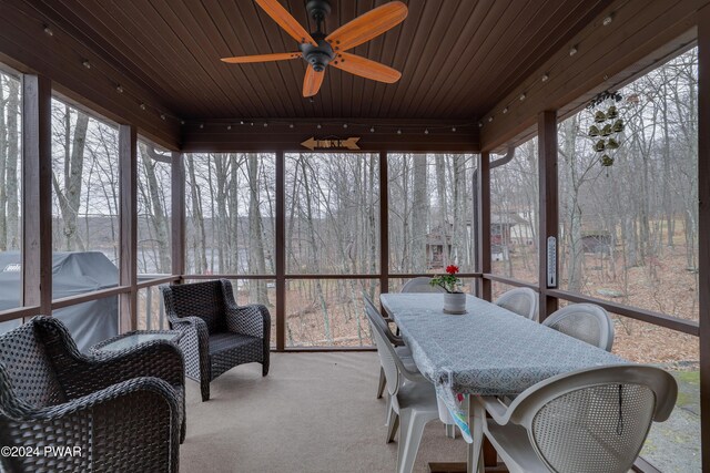 sunroom / solarium with ceiling fan, a healthy amount of sunlight, and wood ceiling