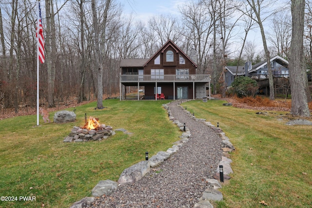 view of front of home featuring a front yard, an outdoor fire pit, and a wooden deck