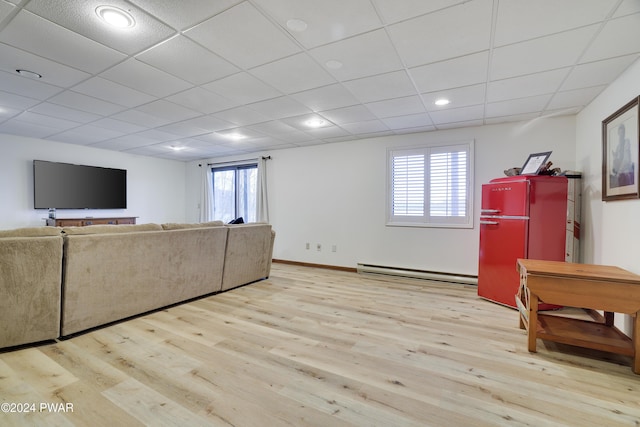 living room featuring a healthy amount of sunlight, a baseboard radiator, and light wood-type flooring