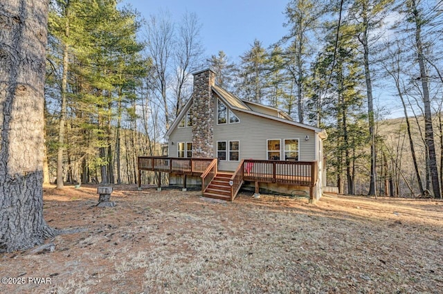 back of house with a wooden deck and a chimney