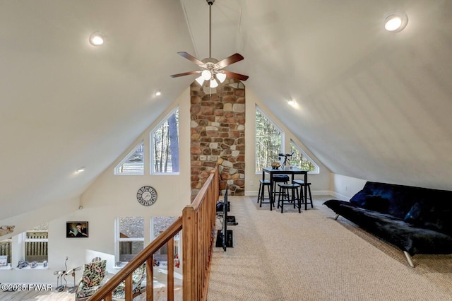 living area with baseboards, lofted ceiling, carpet, and an upstairs landing