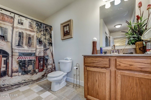 bathroom featuring toilet, vanity, and baseboards