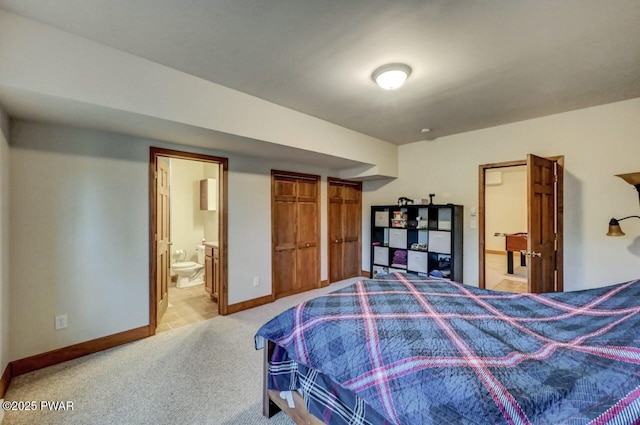 bedroom featuring connected bathroom, light carpet, and baseboards