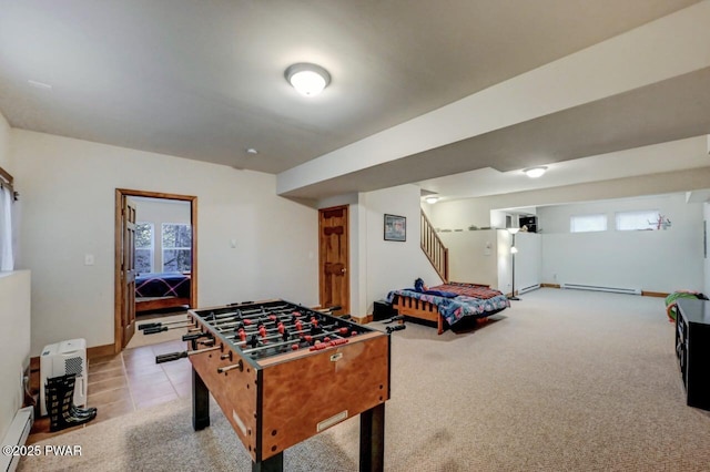 game room with a wealth of natural light, a baseboard radiator, light carpet, and baseboards