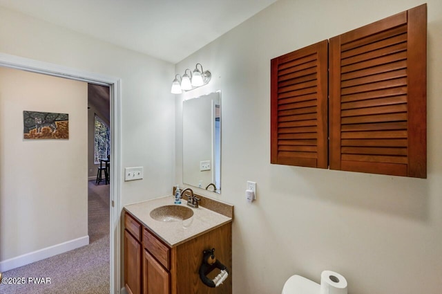 bathroom featuring vanity, toilet, and baseboards