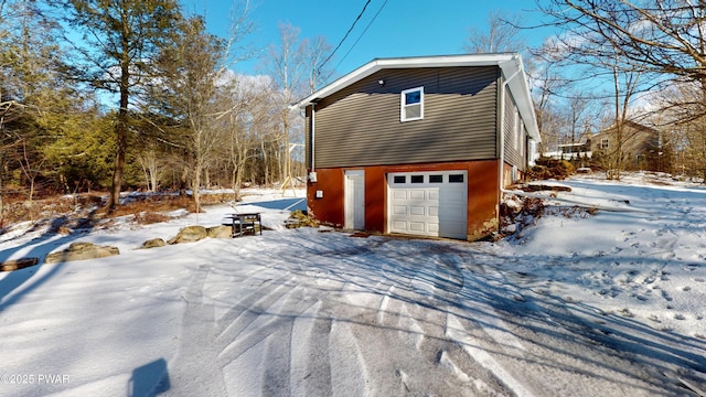 snow covered property with a garage