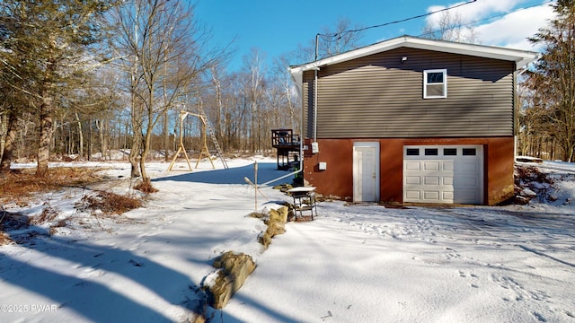 view of snowy exterior featuring an attached garage