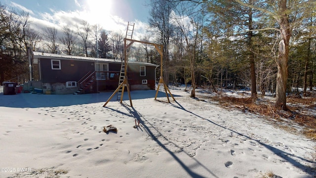 snow covered rear of property featuring metal roof