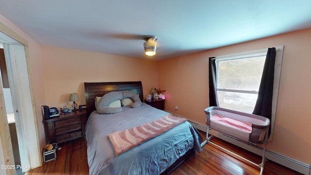 bedroom featuring a baseboard radiator, dark wood finished floors, and a ceiling fan