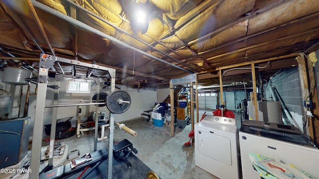 below grade area featuring water heater and washer and clothes dryer