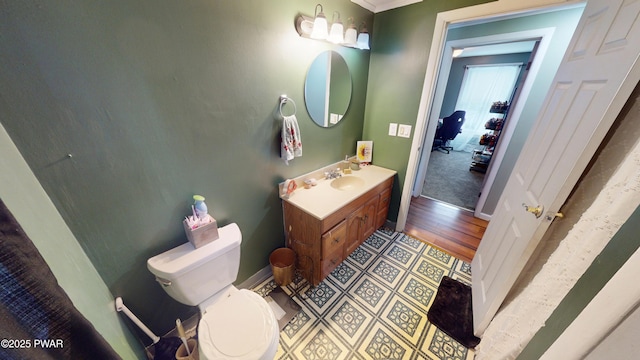 bathroom with toilet, baseboards, and vanity