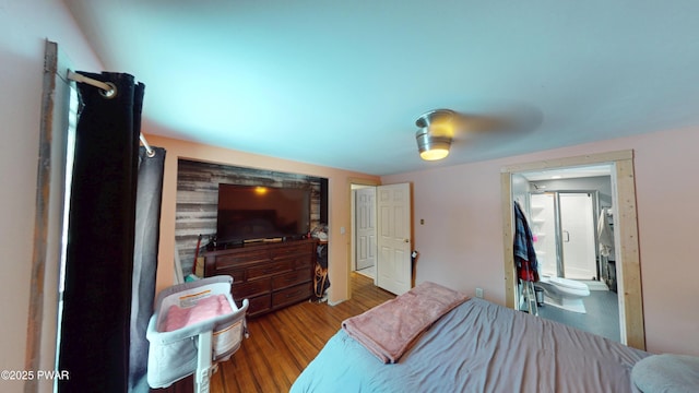 bedroom with connected bathroom and light wood-style floors