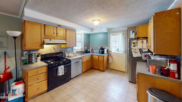 kitchen featuring brown cabinets, light countertops, appliances with stainless steel finishes, a sink, and exhaust hood