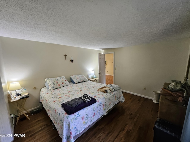 bedroom featuring a textured ceiling and dark hardwood / wood-style flooring