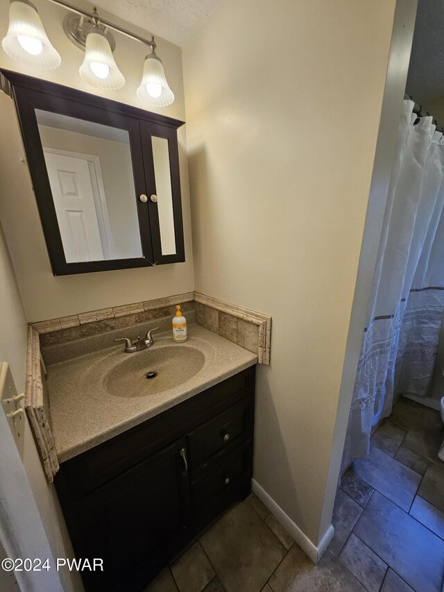 bathroom with a textured ceiling and vanity