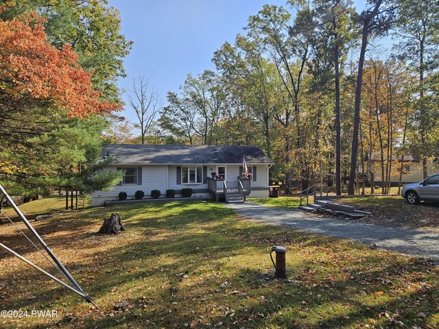 view of front of property with a wooden deck and a front yard