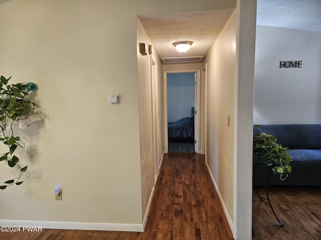 corridor featuring dark hardwood / wood-style floors and a textured ceiling