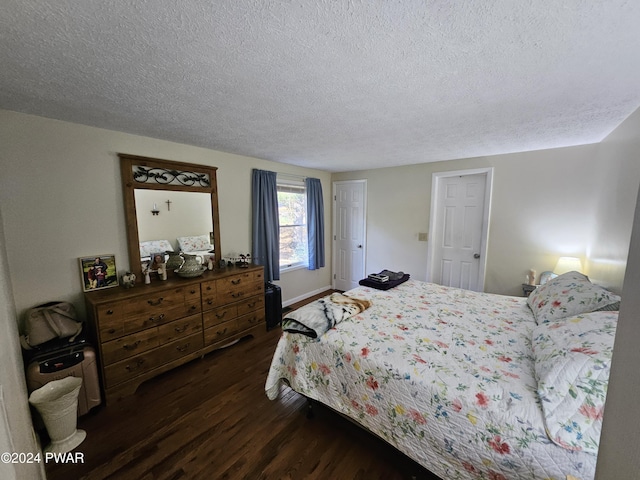 bedroom with dark hardwood / wood-style flooring and a textured ceiling