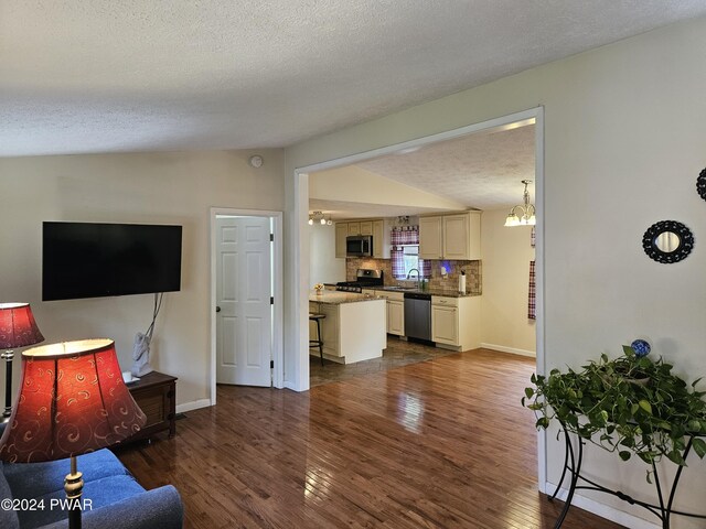 living room featuring a notable chandelier, dark hardwood / wood-style flooring, lofted ceiling, and a textured ceiling