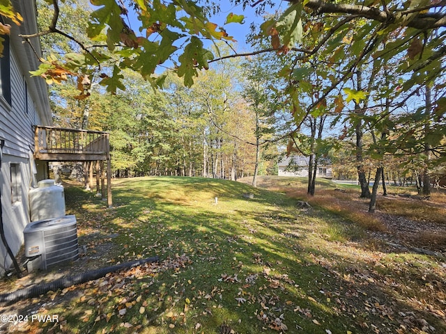 view of yard with cooling unit and a deck