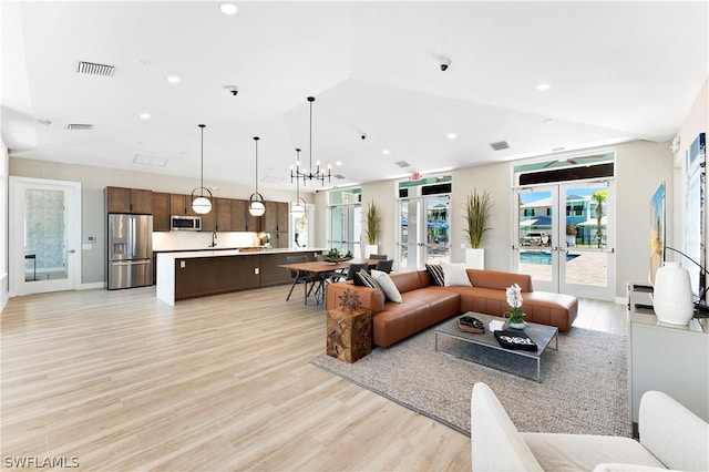 living room featuring recessed lighting, french doors, visible vents, and light wood finished floors