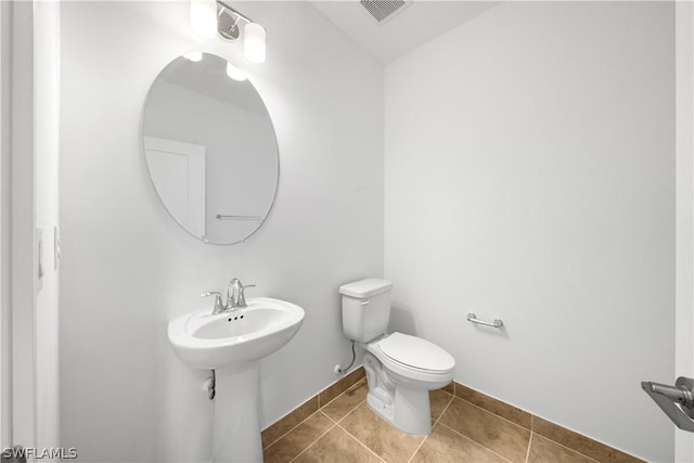 bathroom with tile patterned floors, toilet, visible vents, and baseboards