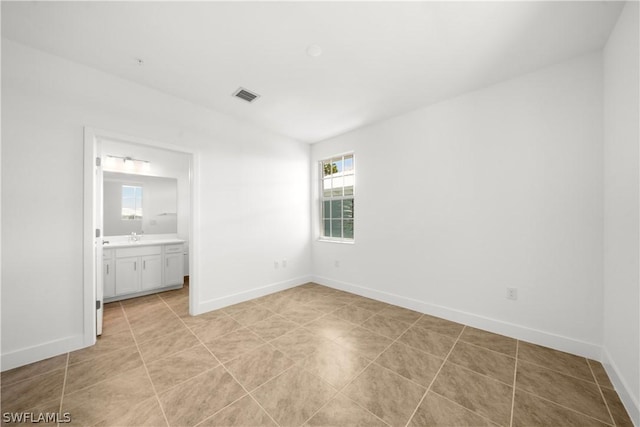 unfurnished room with light tile patterned floors, visible vents, and baseboards