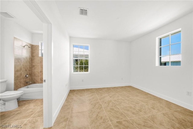 interior space featuring tile patterned floors, visible vents, and baseboards